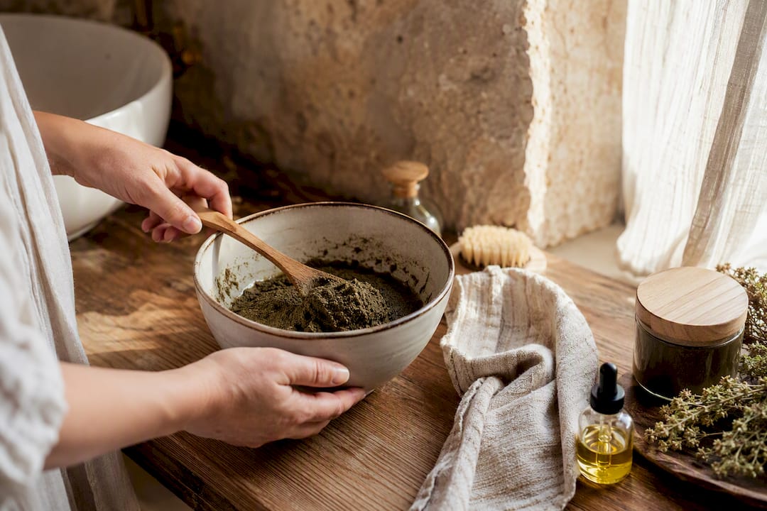 Mani che preparano un rimedio naturale per capelli in una ciotola